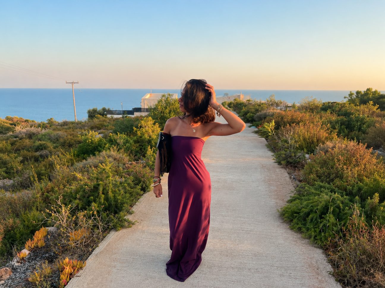 The Grace Dress by JIEN in midnight burgundy, buiten aan de kust